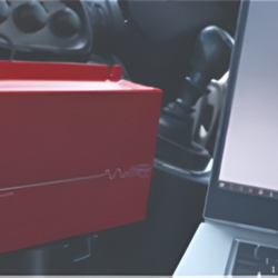 close up of red power inverter next to a laptop.